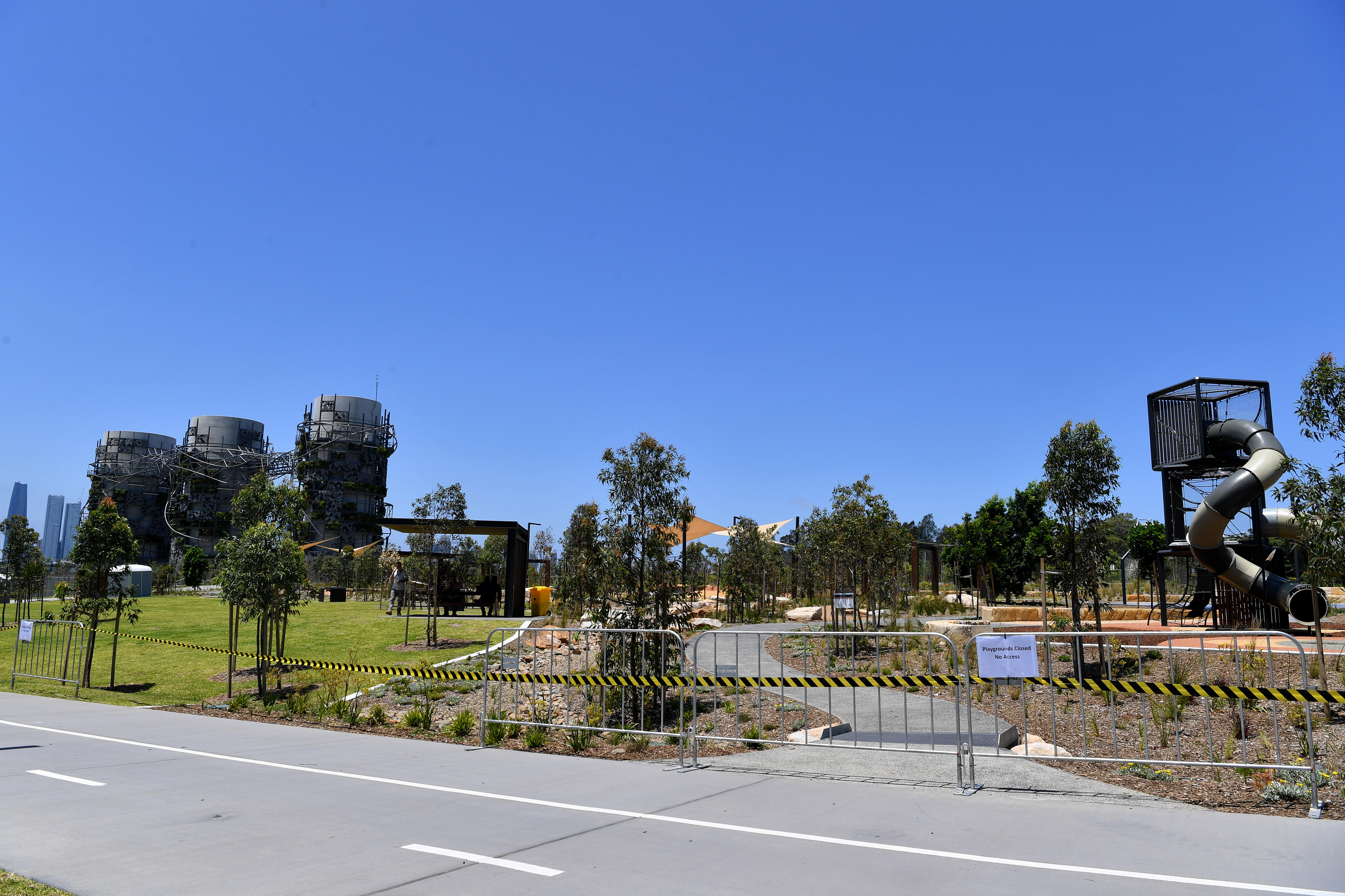 A children's playground is closed off with gates with a notice attached to the gates.