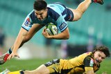 Jack Maddocks flies through the air while carrying the ball, as a Force player lays on the ground under him and watches