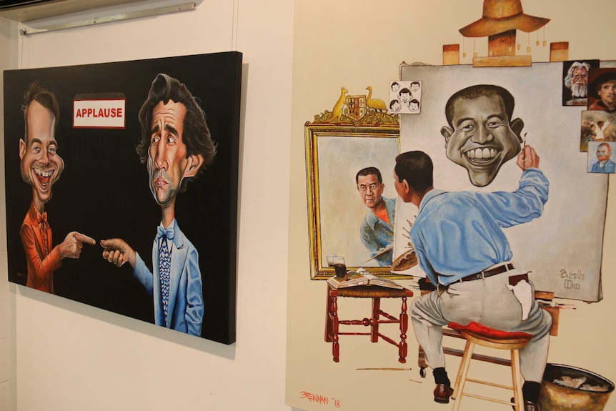 Paintings of Ahn Do and Hamish & Andy hang in a gallery.