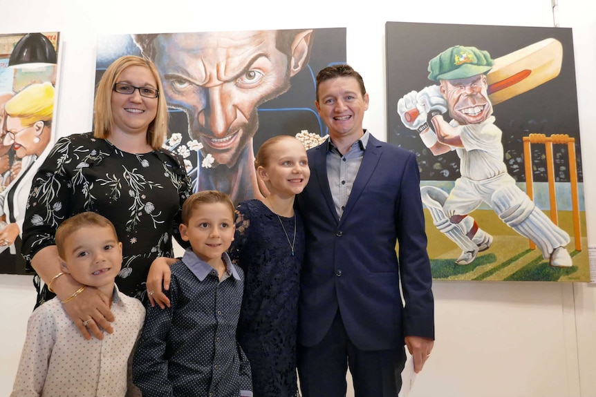 Winning artist James Brennan with his family in front of his two Bald Archy entries for 2017.