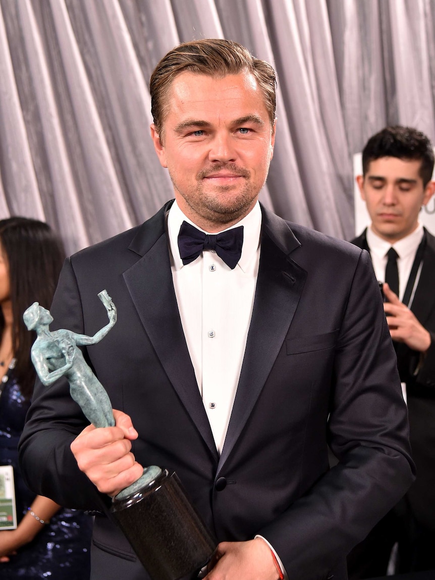 Leonardo DiCaprio holds his SAG award in his left hand