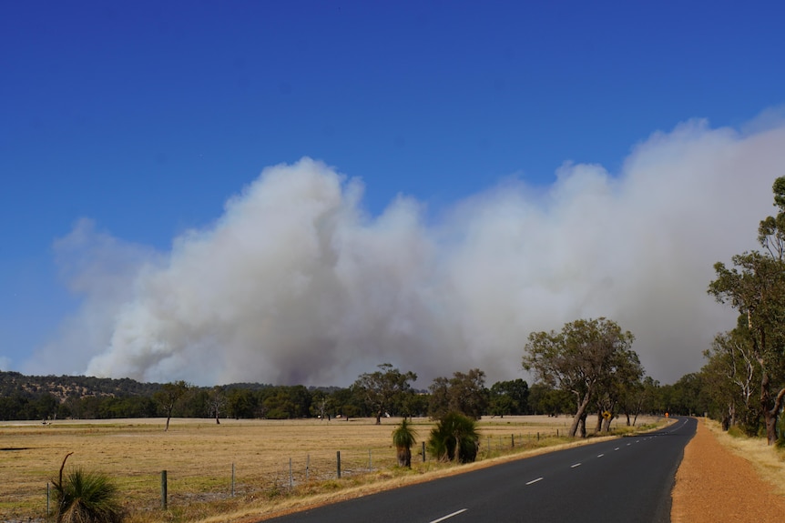 A road south of Perth, with smoke billowing on the horizon.