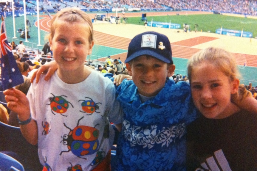 Three siblings in a stadium at the 2000 Sydney Olympics