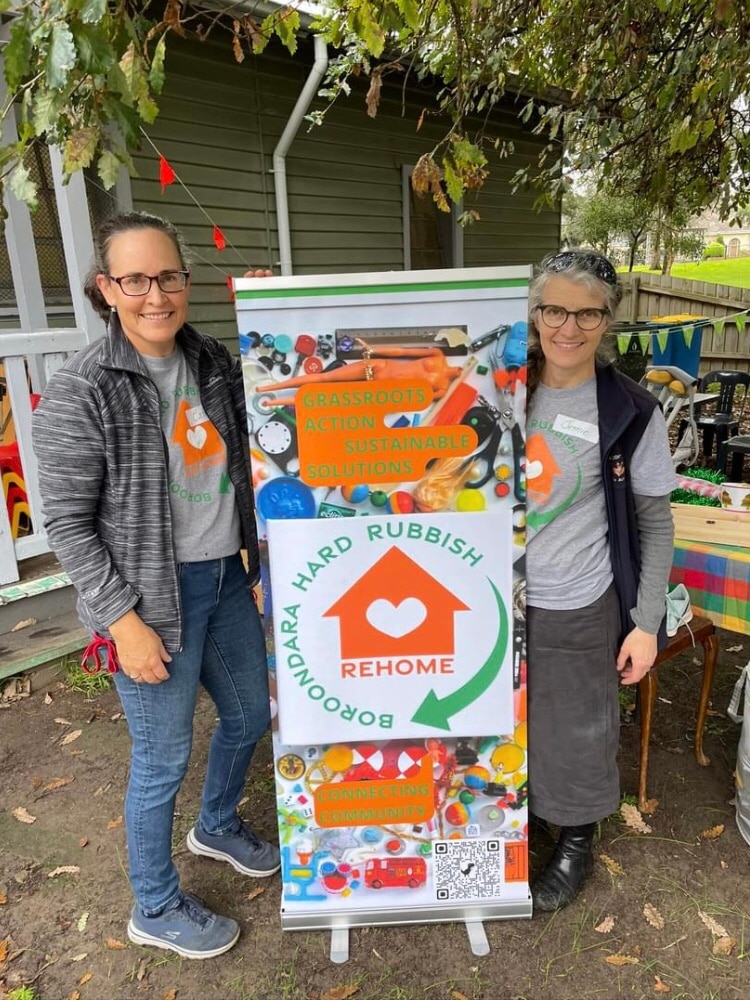 Booroondara Hard Rubbish Rehome founders Catherine and Jennie smile while holding a sign.