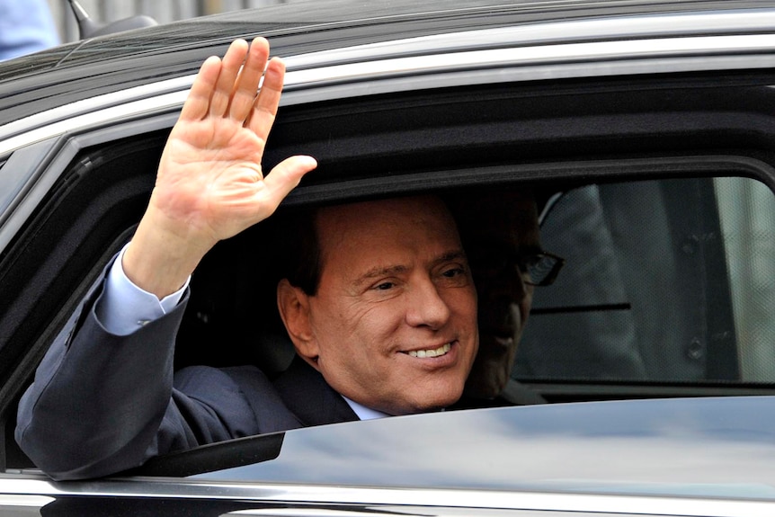 Mr Berlusconi waves as he leaves the Justice Palace in Milan on September 19, 2011.