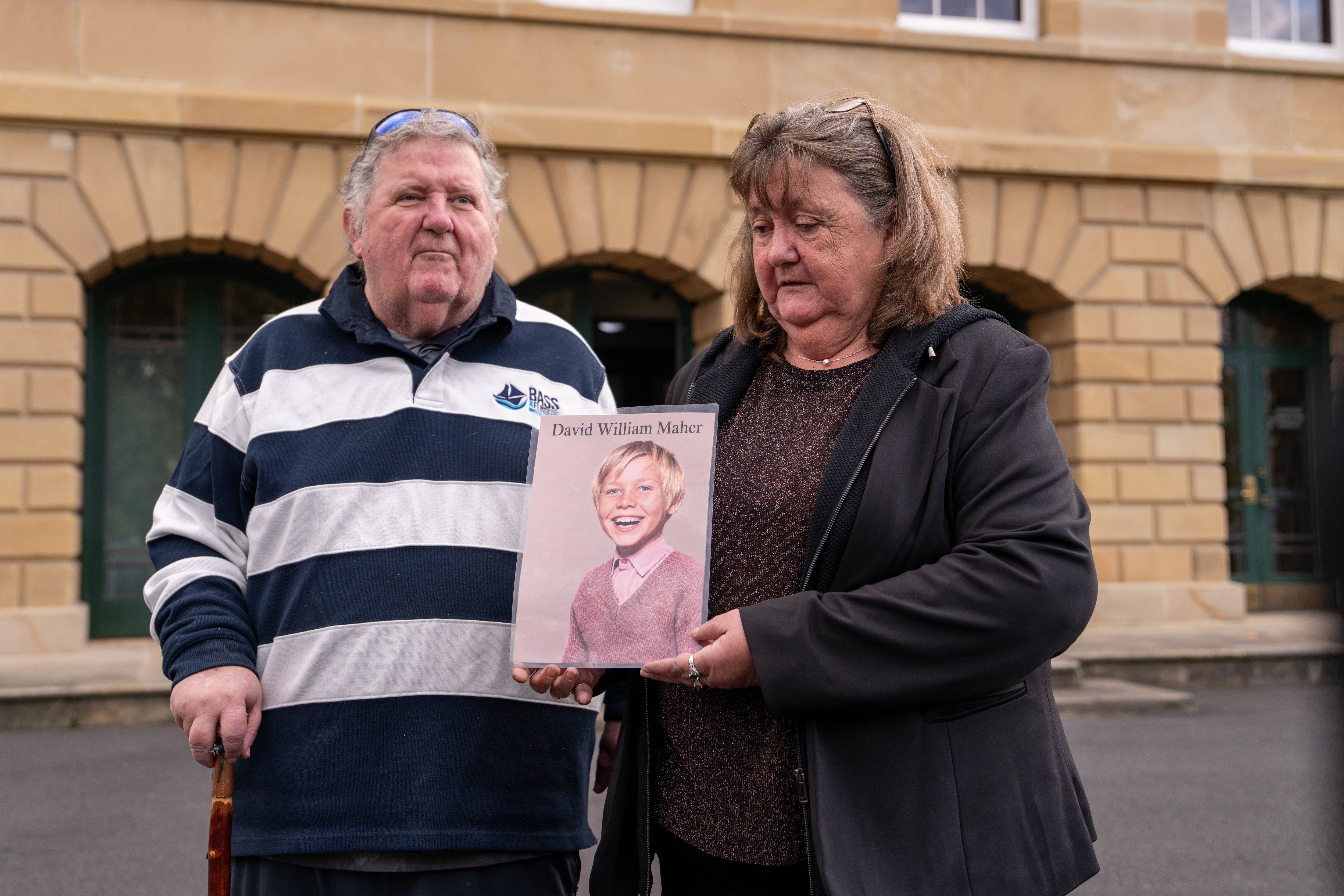 Group standing out front of parliament holding a picture of their lost brother.