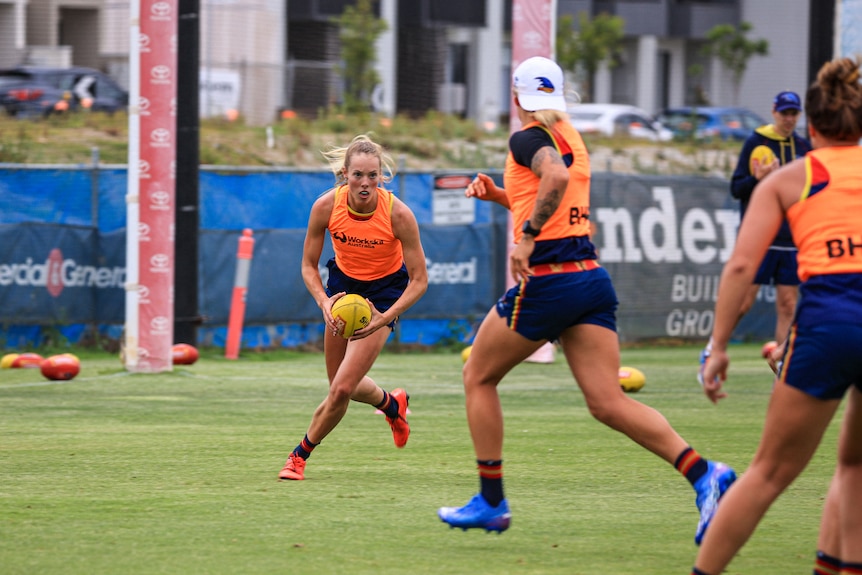 Jasmine Simmons looking downfield with ball in hand at Adelaide Crows pre-season training.