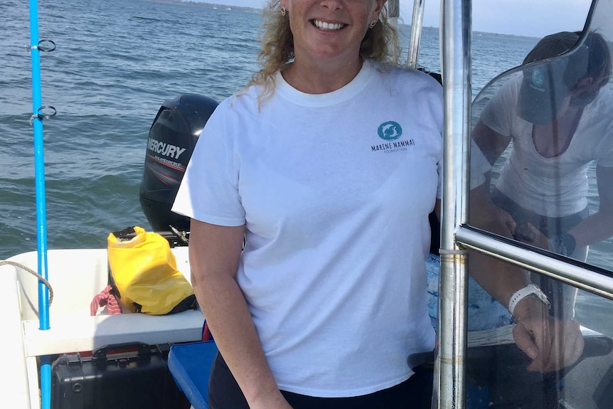 Dr Kate Robb standing on a boat on lake