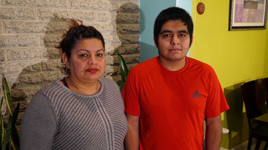 El Salvadoran migrant Helen Avalos stands next to her son Uriel