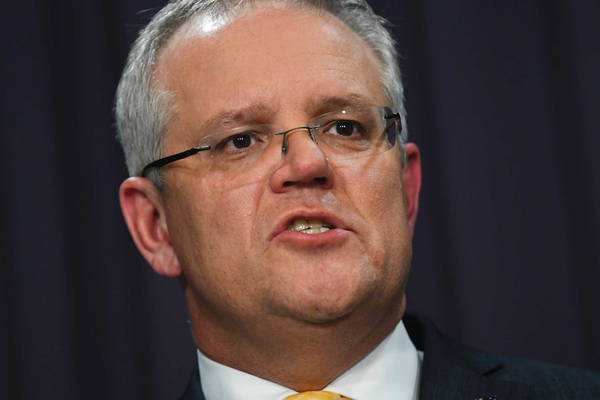 The Prime Minister of Australia wears a dark suit and yellow tie.