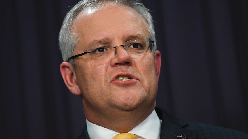 The Prime Minister of Australia wears a dark suit and yellow tie.