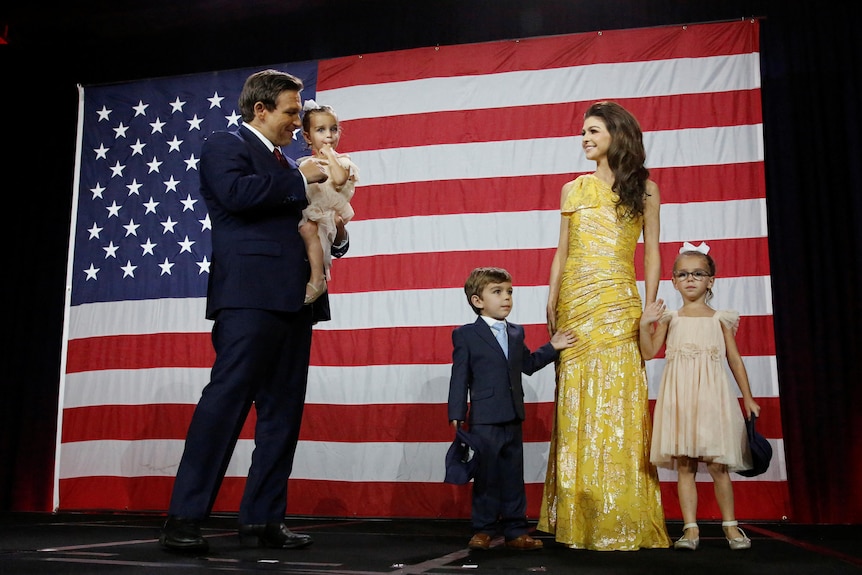Ron DeSantis holds a baby girl, while his wife Casey holds hands with a boy and girl
