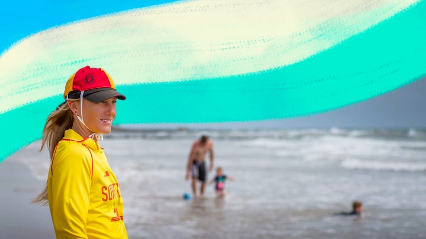 Surf lifesaver on the beach in her uniform looking out towards the ocean for a story about declining volunteering in Australia.