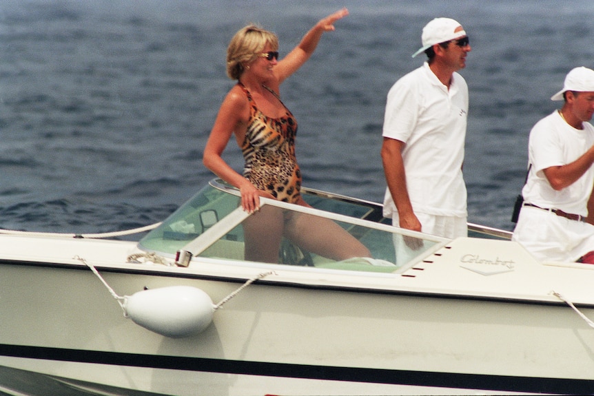 Princess Diana standing aboard a speedboat wearing a leopard and tiger print swimsuit