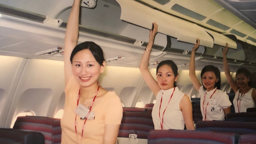 Rebecca Sy and three colleagues reach up to the overheard luggage compartments.