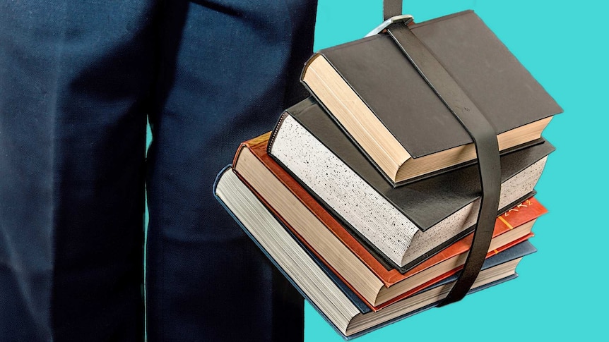 A stack of hardback school-books tied together and carried with a belt.