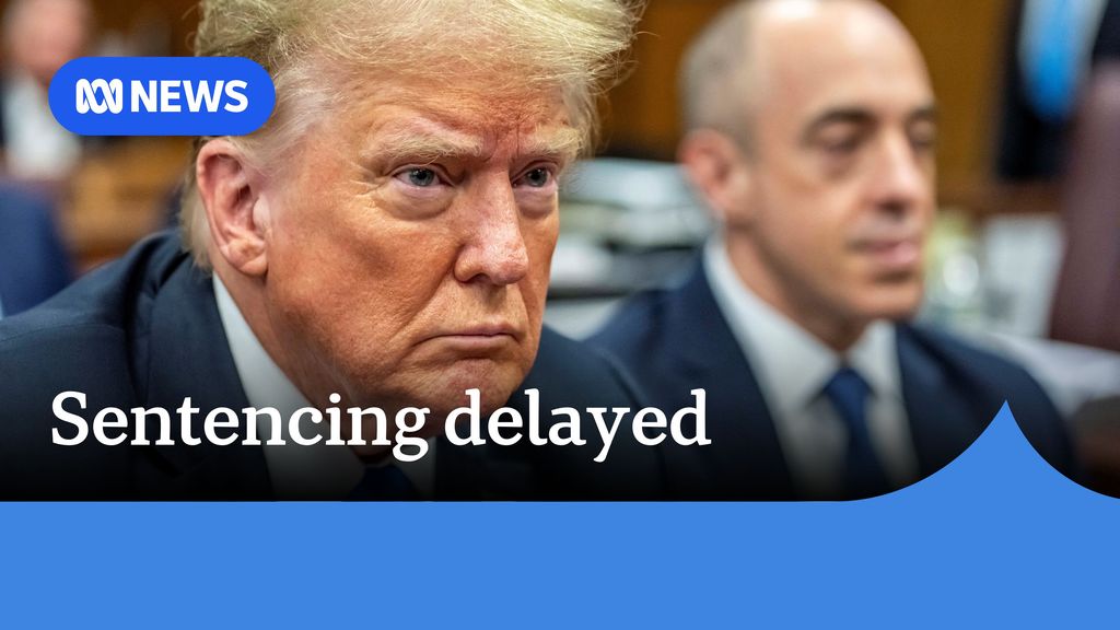 Sentencing delayed: Donald Trump with a neutral expression. A man is out-of-focus behind him.