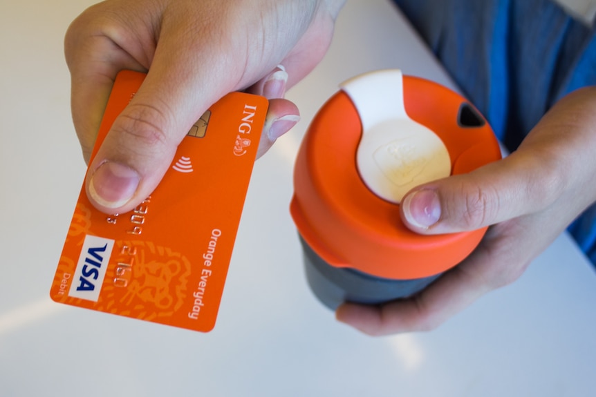 Person paying for a coffee with a credit card.