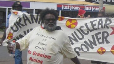 Marching in front of an anti-uranium sign is Pastor Geoffrey Stokes in Kalgoorlie in 2011.