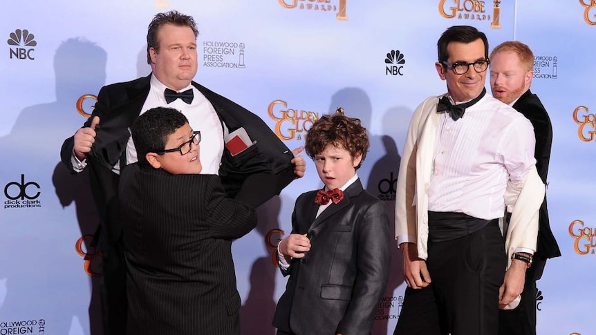 picture of 3 men and two boys from the modern family posing on the red carpet