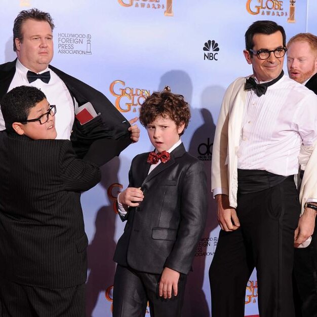 picture of 3 men and two boys from the modern family posing on the red carpet