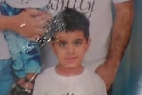 A boy poses for a family photo.