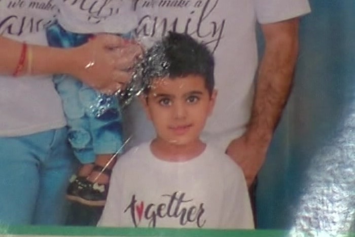 A boy poses for a family photo.