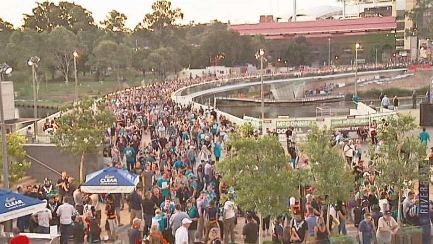 Crowd crosses the Torrens footbridge from Adelaide Oval