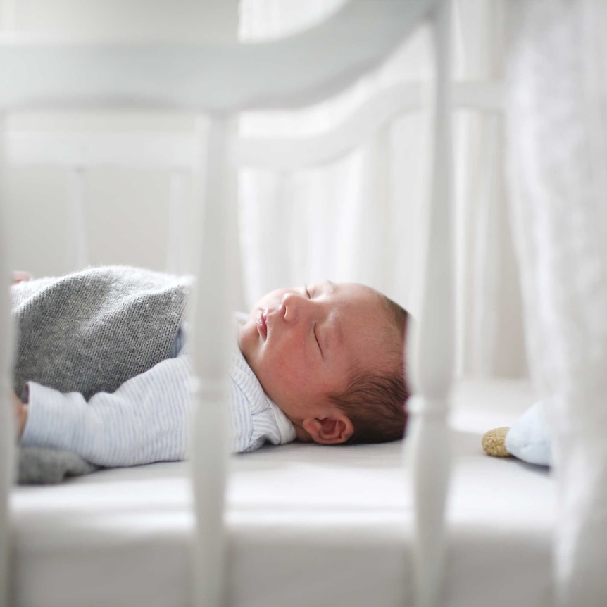 Baby asleep in cot