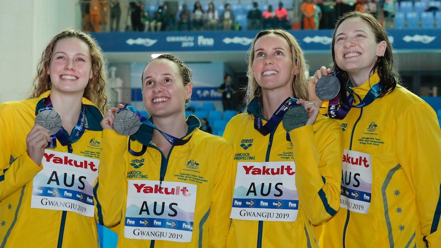 Australia's women's 4x100m medley relay team glance up as they hold their silver medals.