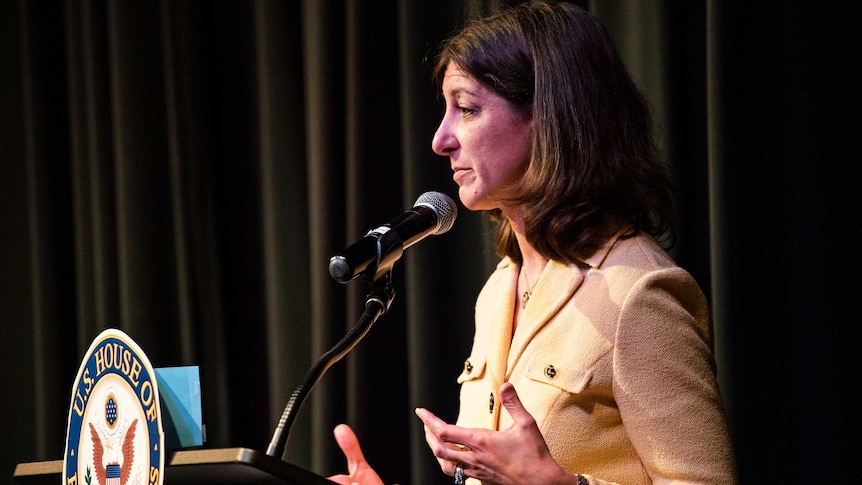 Elaine Luria looks into the crowd while standing on stage.