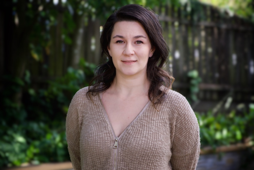 A woman smiles at the camera