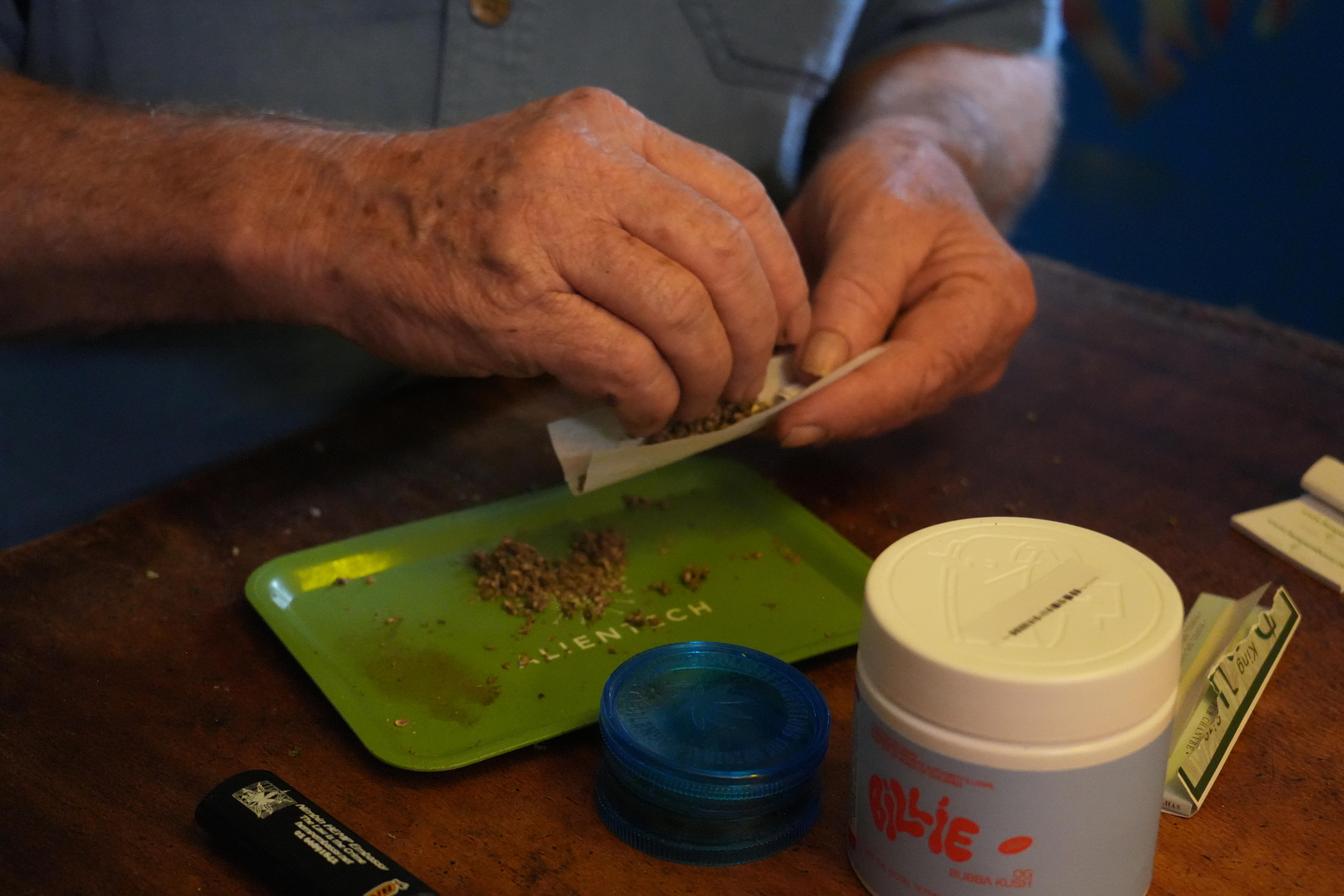 Michael Balderstone prepares a cannabis joint.