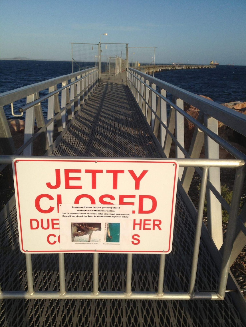 A jetty with a closed sign on a gate.