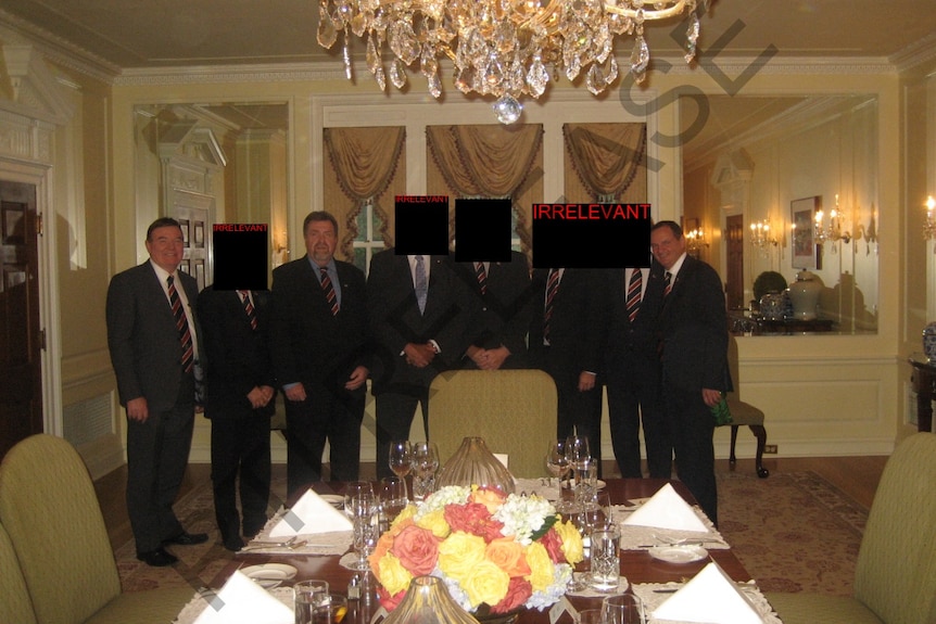 Carl Wulff, Paul Tully and Paul Pisasale stand with a group for a dinner at a hotel in the US