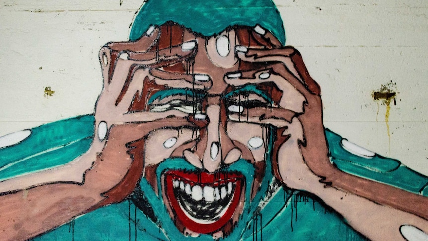 Graffiti artwork of a man holding his head in pain