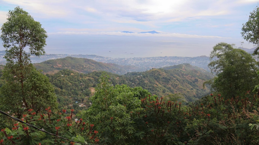 High photo of the east timor landscape with green ranges and the ocean in the distance.