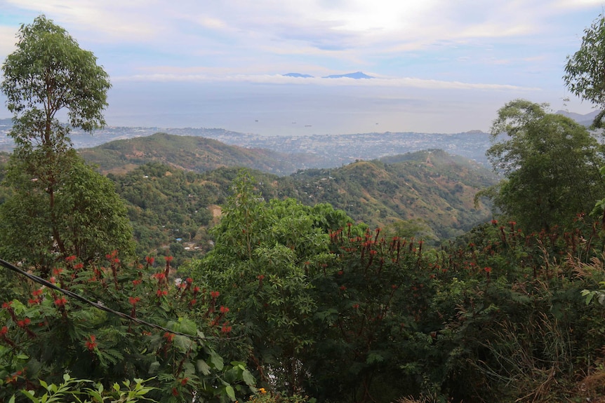 High photo of the east timor landscape with green ranges and the ocean in the distance.