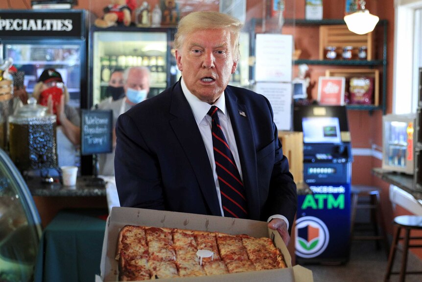 Donald Trump holding a pizza