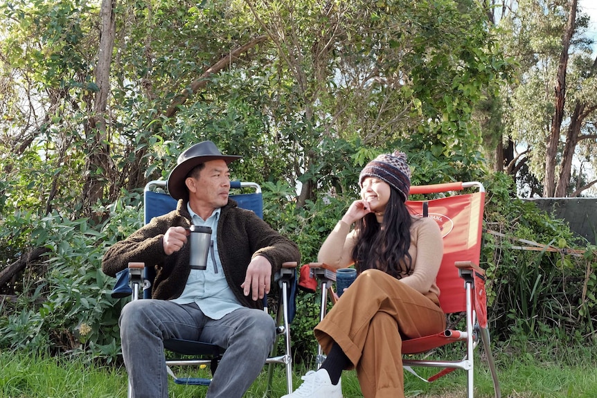 A young woman and her dad camping outside in Australia.