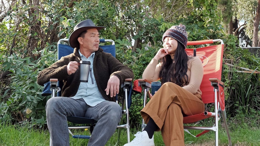 A young woman and her dad camping outside in Australia.