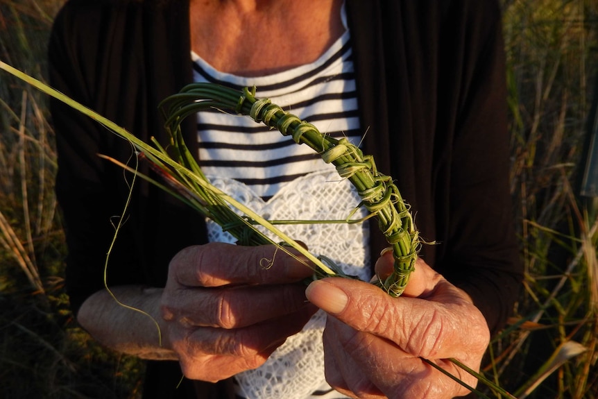 Aboriginal artist Yvonne Koolmatrie weaves some grass
