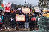 People stand at Melbourne's Fed Square with signs reading 72 years of bleeding in Kashmir and We Sikhs stand with you.