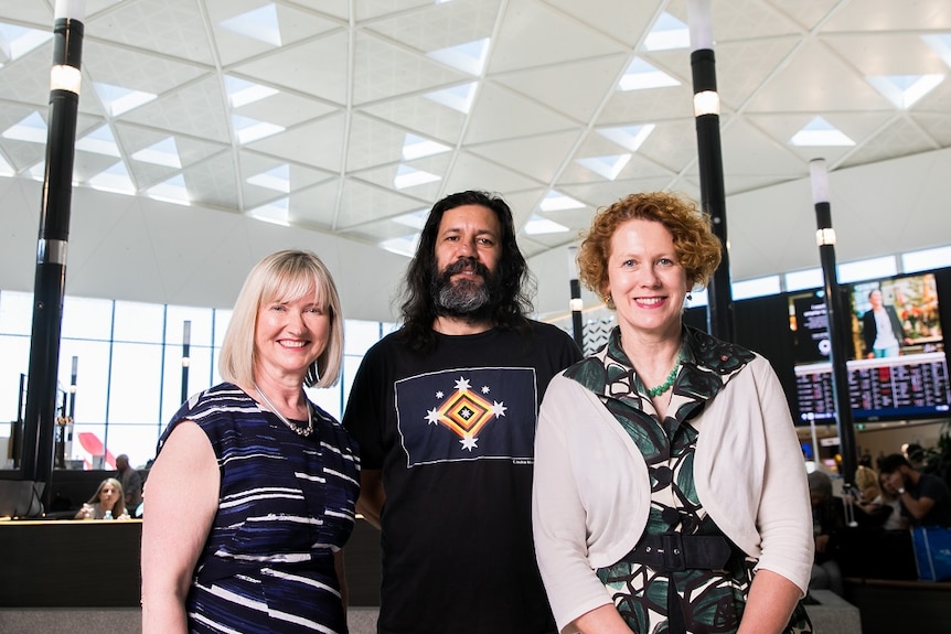 Sydney Airport CEO Kerrie Mathew, Archie Moore and MCA Director Elizabeth Ann Macgregor stand in T1 terminal.