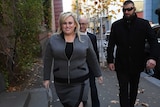 Rebel Wilson smiles at the media as she walks into the Supreme Court in Melbourne.