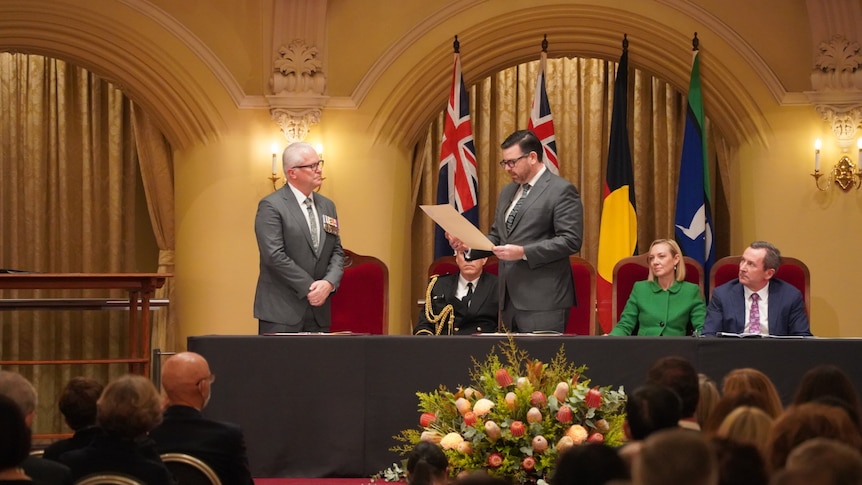Chris Dawson taking the oath of office at a ceremony