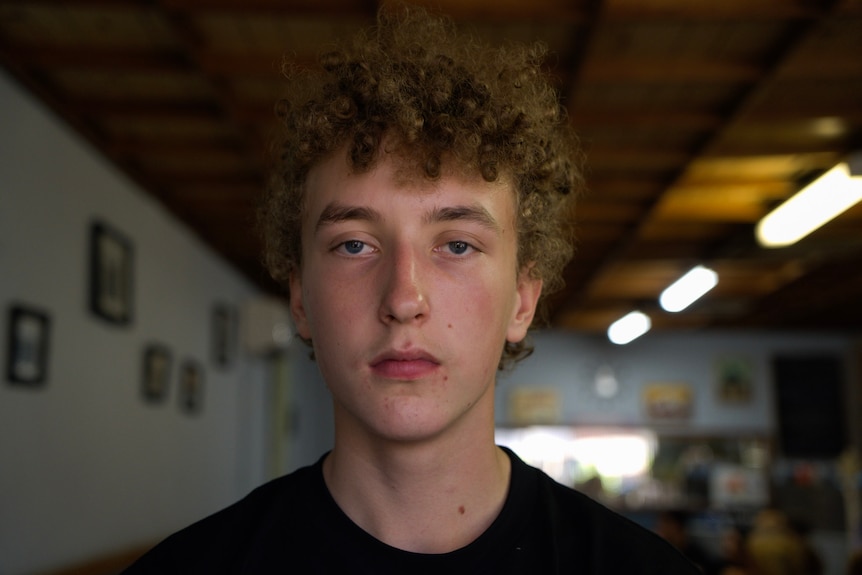 Boy with blonde curls looking at camera close up