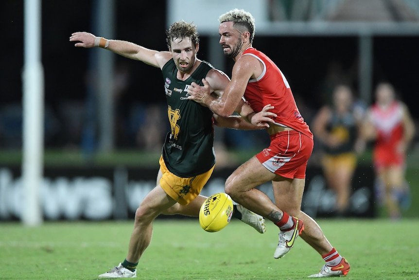 A Saint Mary's player is tackled by a Waratah player.