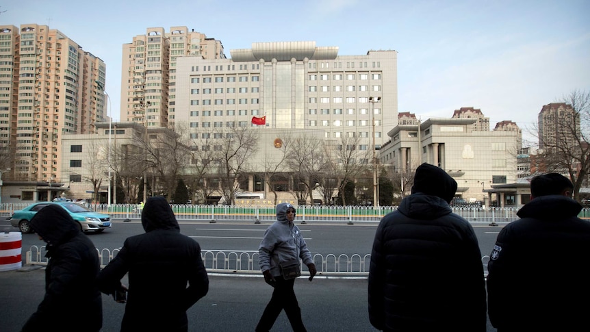 Plainclothes security officers stand in the street opposite  Tianjin No.2 Intermediate court.