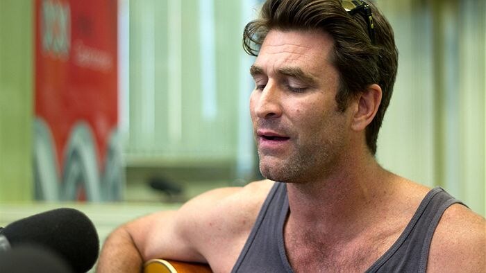Pete Murray playing guitar and singing at the ABC Capricornia Studios